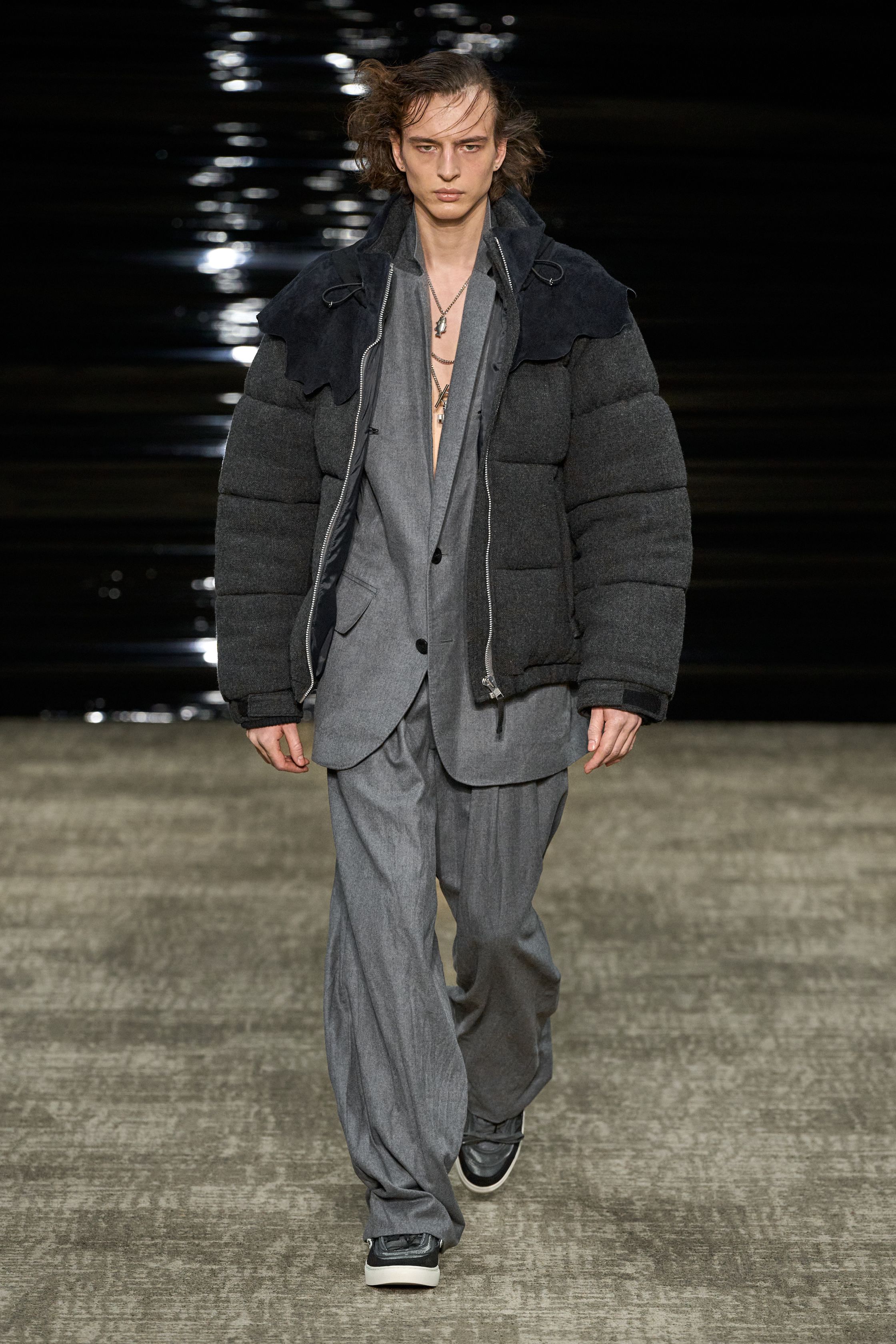 Kolor 26FW 在安静中完成高难度结构表达。层叠、错位、混材质成为视觉主线，运动、正装与工装被精准缝合，却不显拼贴痕迹。色彩克制、比例讲究，服装在行走间展现微妙动态。Kolor 的价值不在“第一眼冲击”，而在长期穿着中逐渐显露的结构智慧，是典型为成熟审美者准备的高完成度男装-顽石频道趋势研究